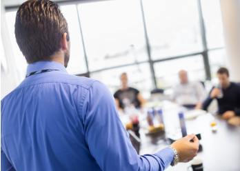 man giving presentation to people at conference table